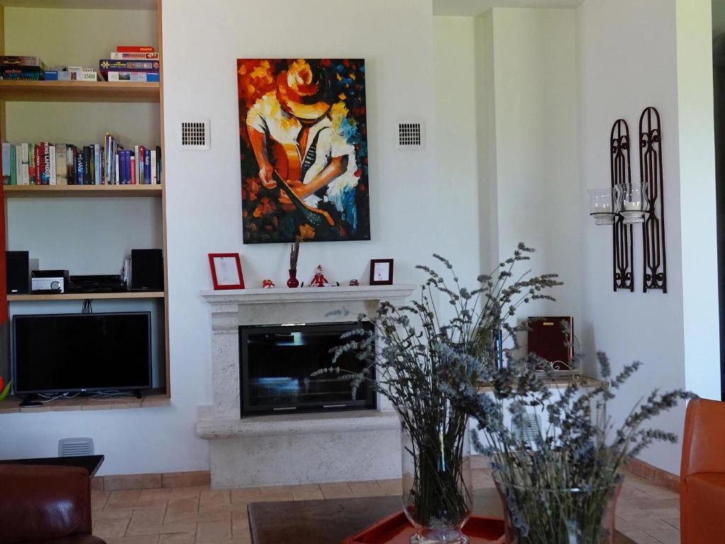 un salon avec une cheminée et un tableau au mur dans l'établissement Luxurious Villa in Vasciano Umbria with Private Pool, à Vasciano