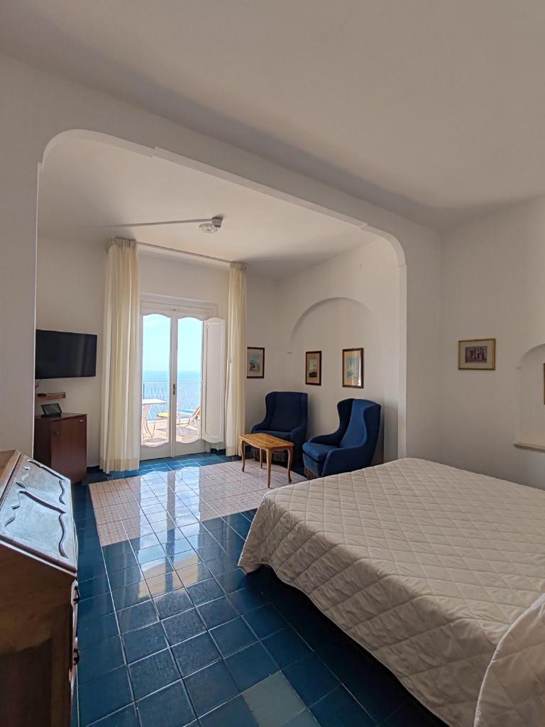 une chambre avec un lit et une vue sur l'océan dans l'établissement Grand Hotel Excelsior, à Amalfi