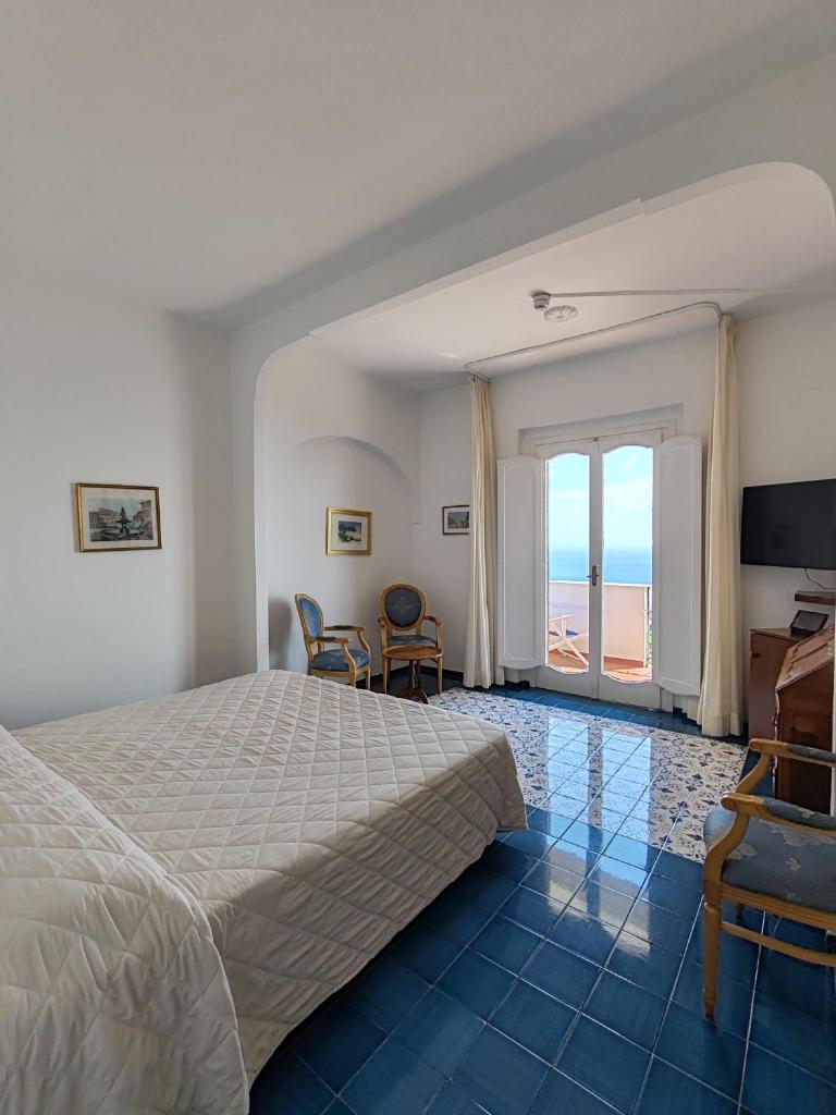 une chambre avec un lit et une vue sur l'océan dans l'établissement Grand Hotel Excelsior, à Amalfi