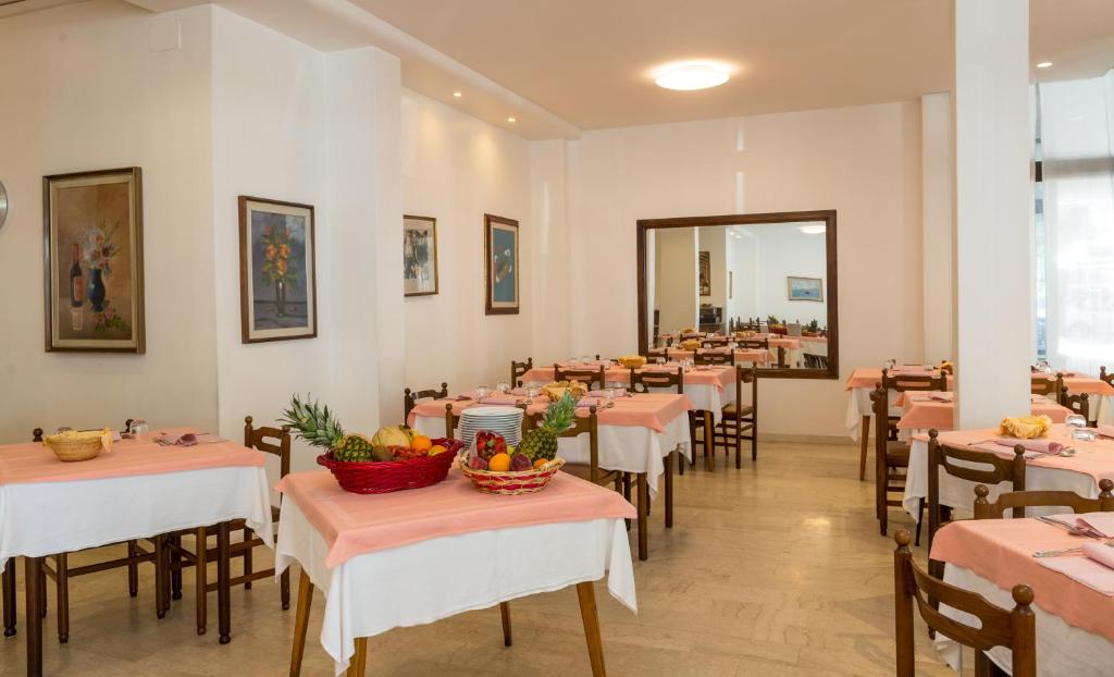 une salle à manger avec des tables et des chaises avec des fruits dessus dans l'établissement Hotel Alla Rotonda, à Lido di Jesolo