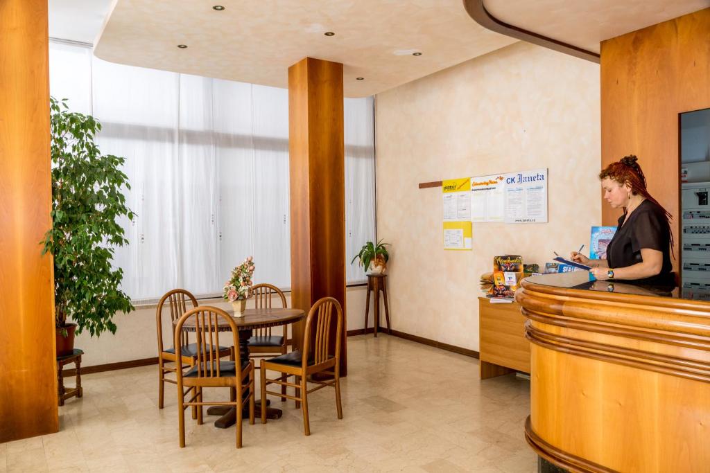 une femme debout au comptoir dans une salle d'attente dans l'établissement Hotel Alla Rotonda, à Lido di Jesolo