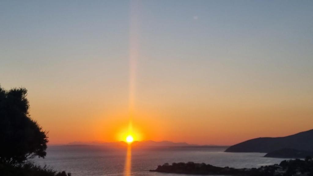 un coucher de soleil sur l'océan avec le soleil dans le ciel dans l'établissement Villetta with heated pool and panoramic view, à Torre delle Stelle