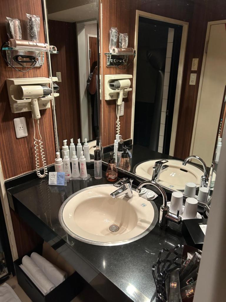 une salle de bain avec deux lavabos et un grand miroir dans l'établissement Hotel AKAIKUTSU - Adult Only, à Yokohama