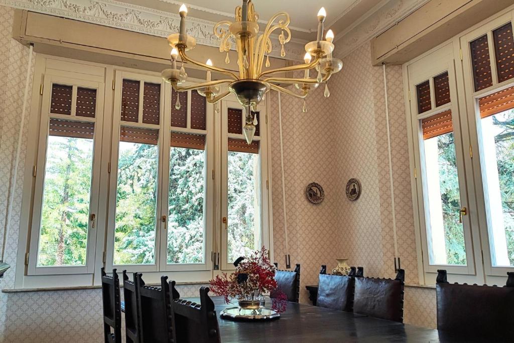 une salle à manger avec une table et un lustre dans l'établissement Villa Fazi - Liberty Style Villa With Private Pool & Park, à Ortezzano
