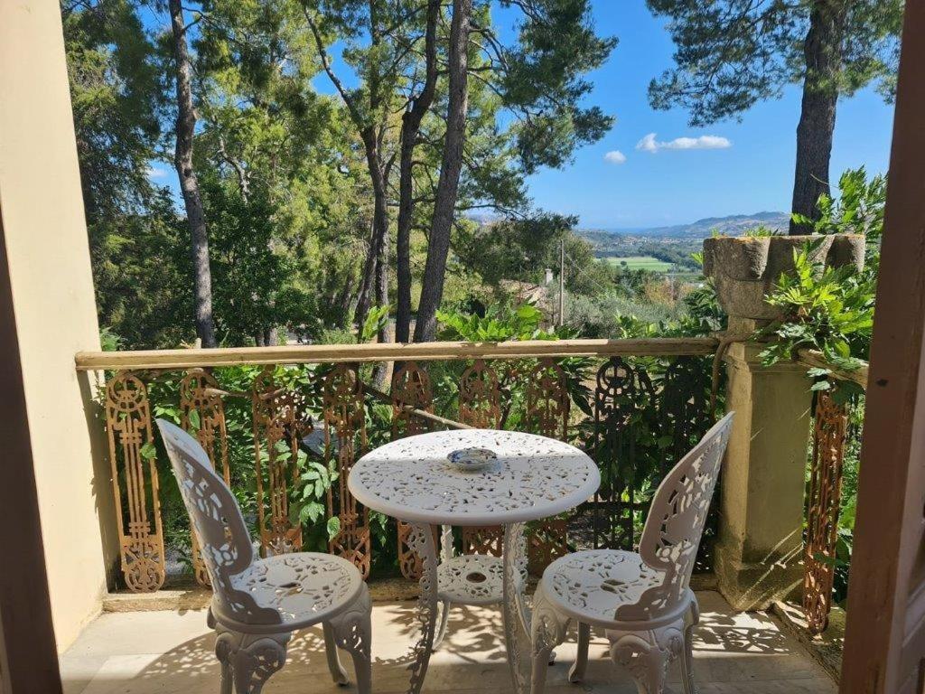 une table et des chaises sur un balcon avec vue dans l'établissement Villa Fazi - Liberty Style Villa With Private Pool & Park, à Ortezzano