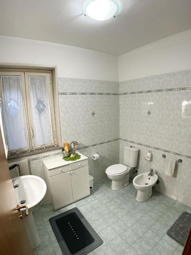 une salle de bain avec un lavabo et des toilettes et un lavabo dans l'établissement Casa Vacanza AcquaMarina, à Acireale