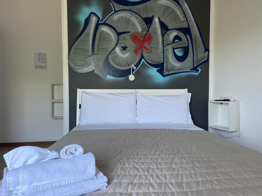 une chambre avec un lit avec un tableau sur le mur dans l'établissement X Hotel, à Punta Marina