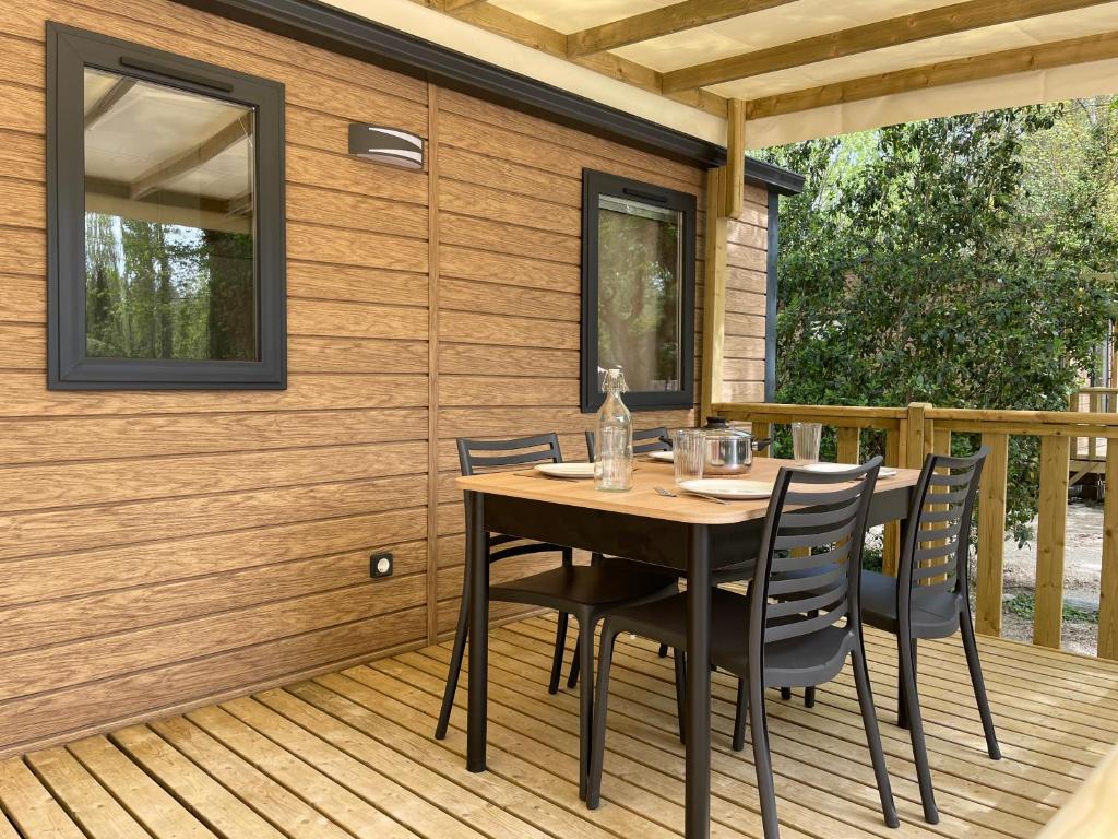 une table et des chaises en bois sur une terrasse dans l'établissement Lodges & Nature - 71, à Avignon