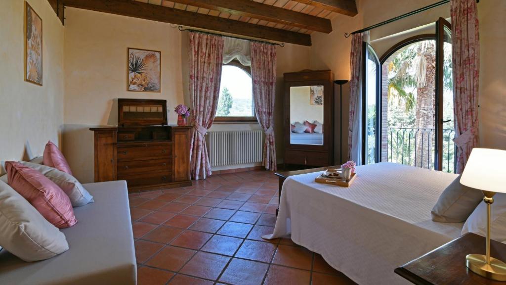 une chambre avec un lit, un canapé et une fenêtre dans l'établissement VILLA BIDDIZZA, à Acireale