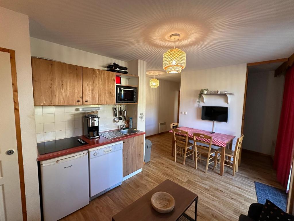 Il comprend une cuisine et un salon avec une table. dans l'établissement Charmant appartement confortable pour 6 personnes 40m2 pied pistes, Piscine, wifi, parking, à Chamrousse