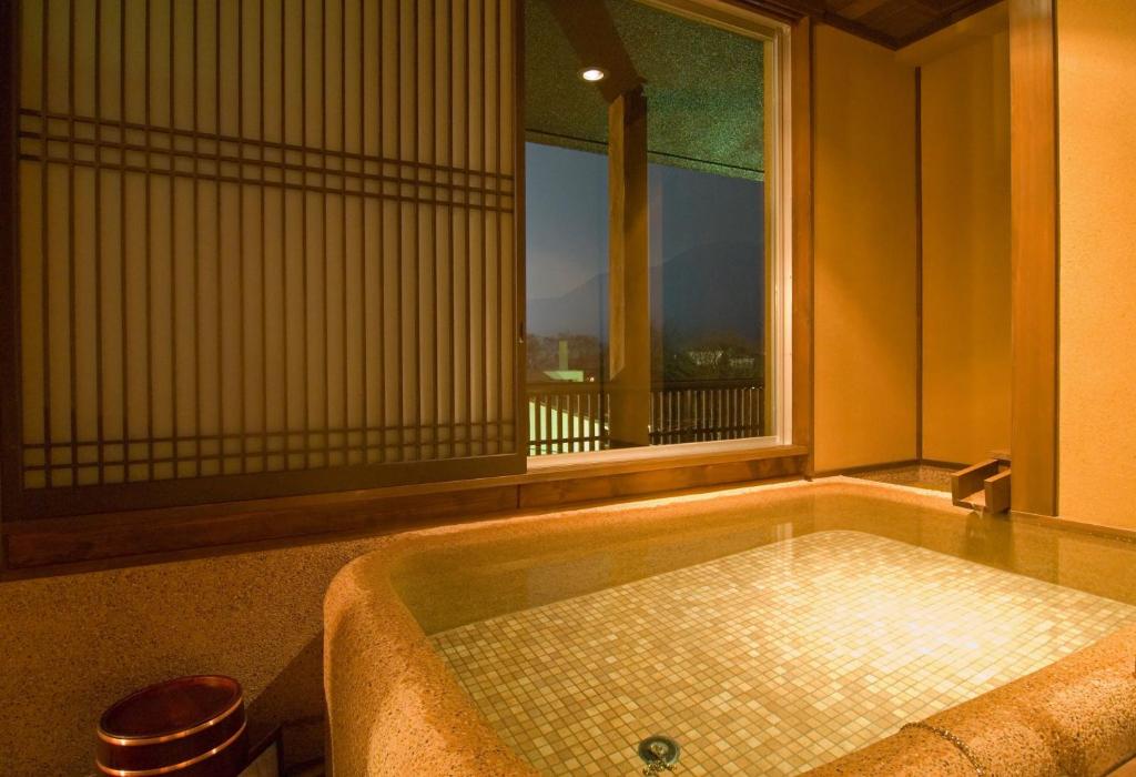 une baignoire dans une pièce avec une fenêtre dans l'établissement Mount View Hakone, à Hakone