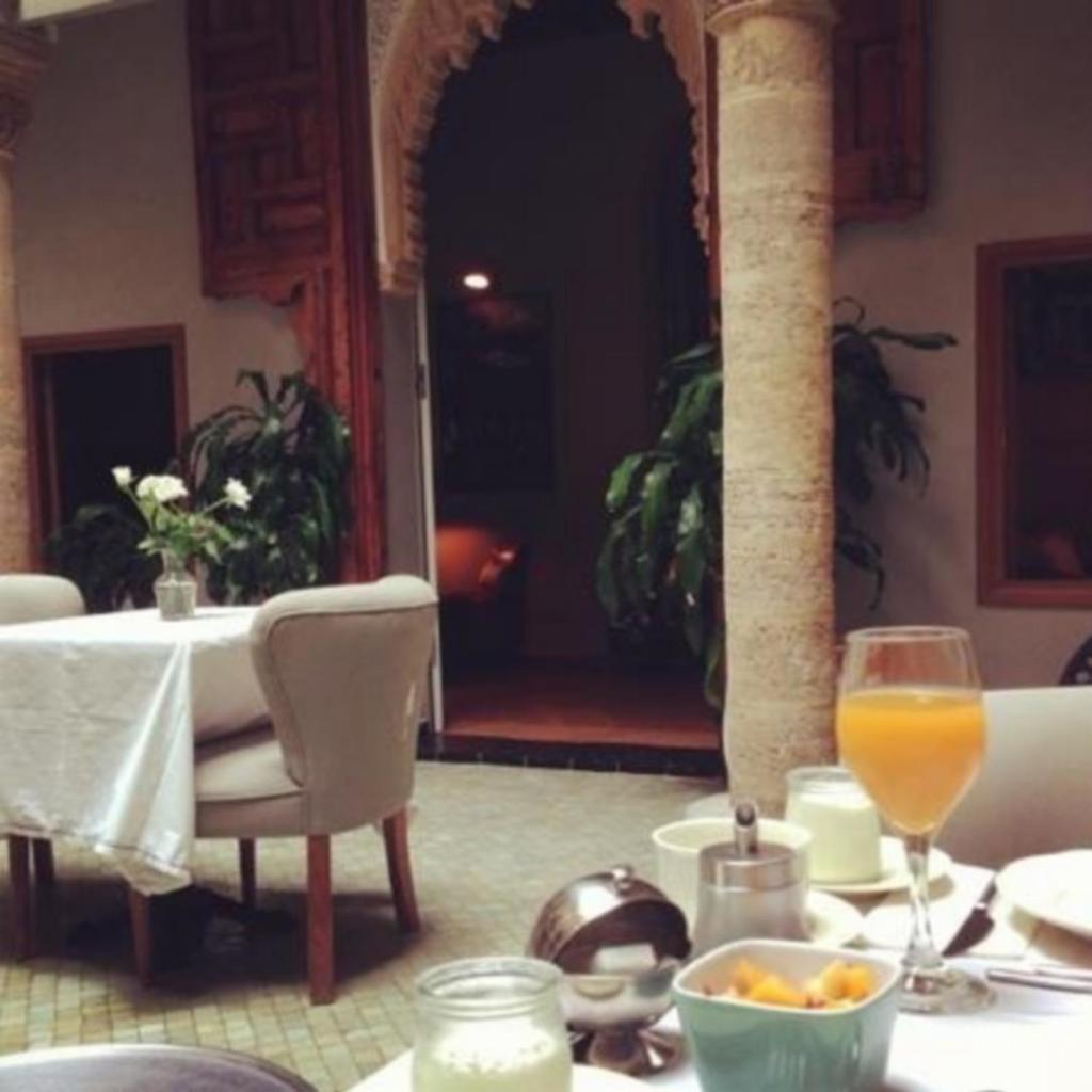 - une table avec un bol de nourriture et un verre de jus d'orange dans l'établissement L'Alcazar, à Rabat