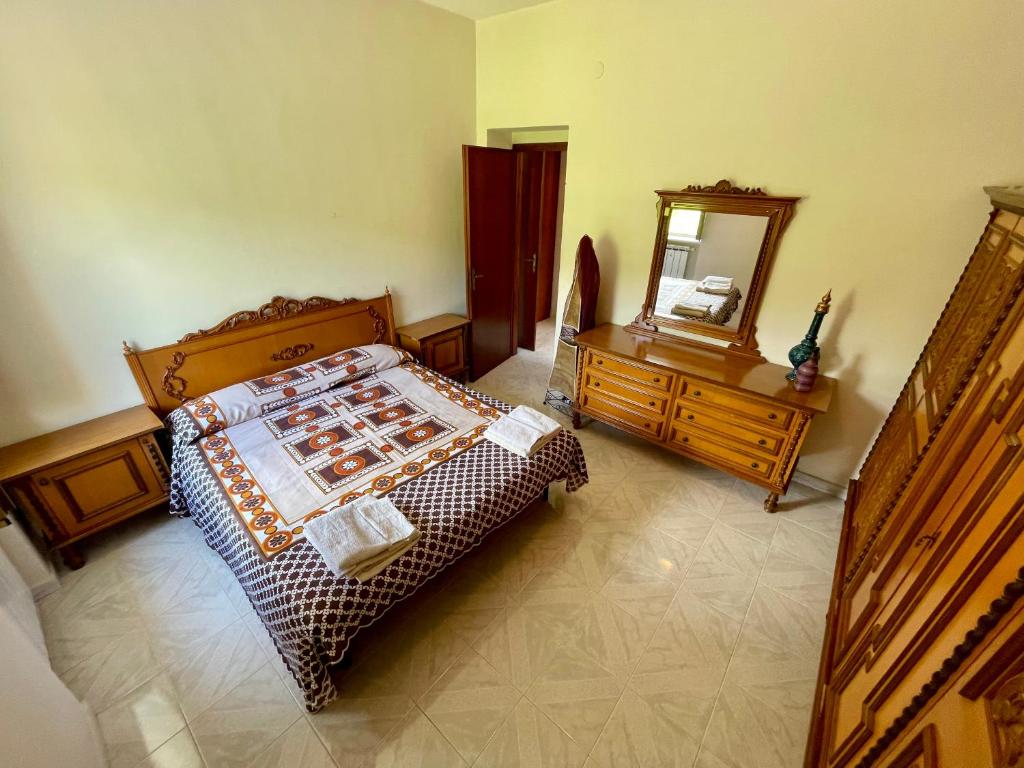 une chambre avec un lit, une commode et un miroir dans l'établissement Villa con Piscina Donna Romina, à Sant'Agata de' Goti 15 autres photos