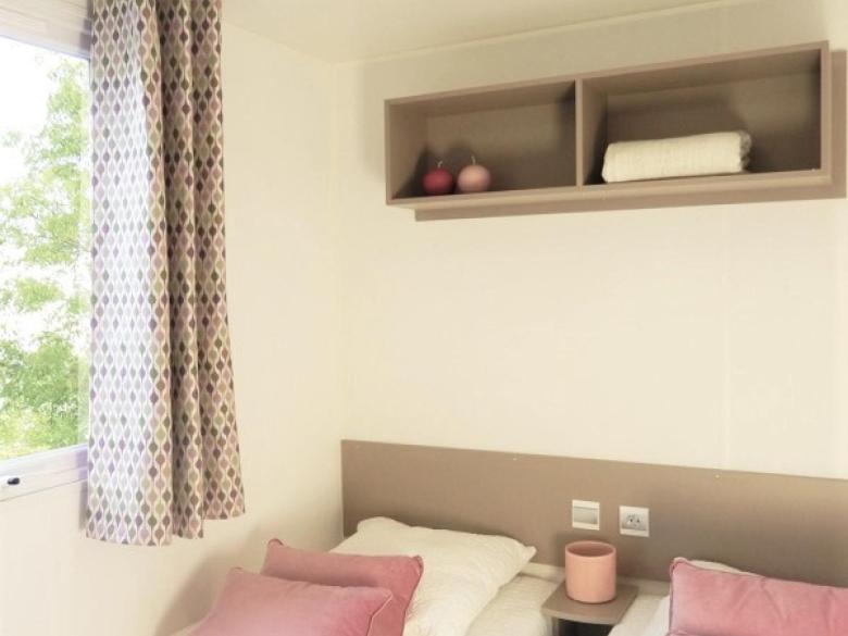 une chambre avec un lit avec des oreillers roses et blancs dans l'établissement Camping Carabasse Vias plage., à Vias 37 autres photos