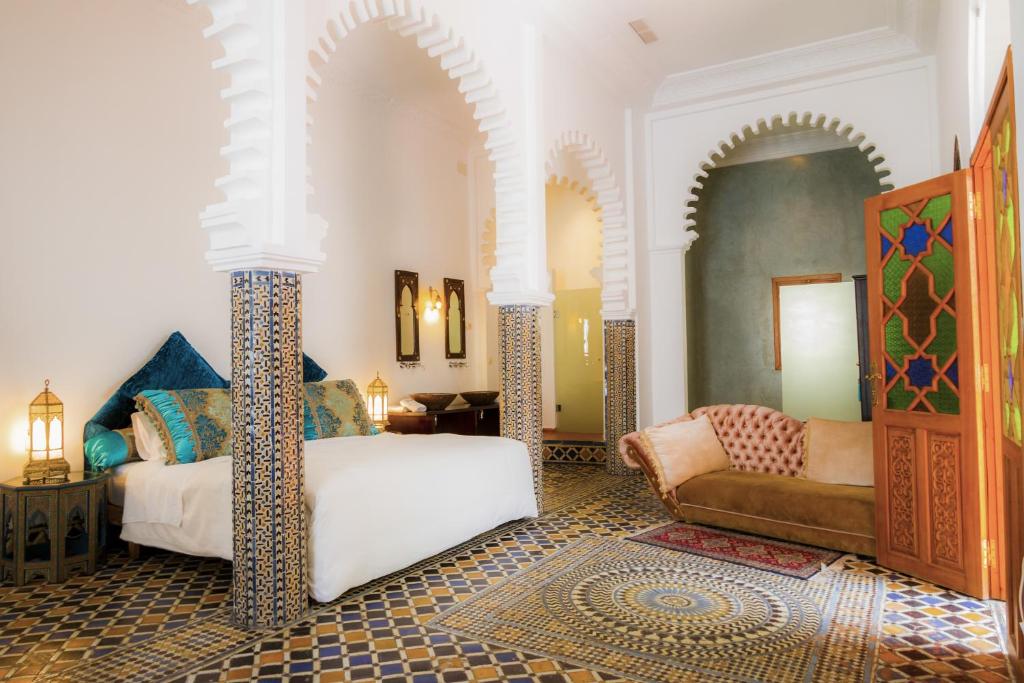une chambre avec un lit et un canapé dans une pièce dans l'établissement Hotel Blanco Riad, à Tetouan