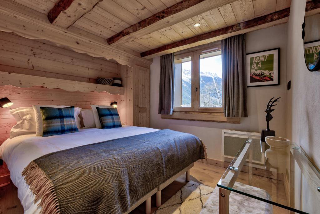 une chambre avec un lit dans une pièce avec une fenêtre dans l'établissement Residence la Blaitiere, à Chamonix-Mont-Blanc