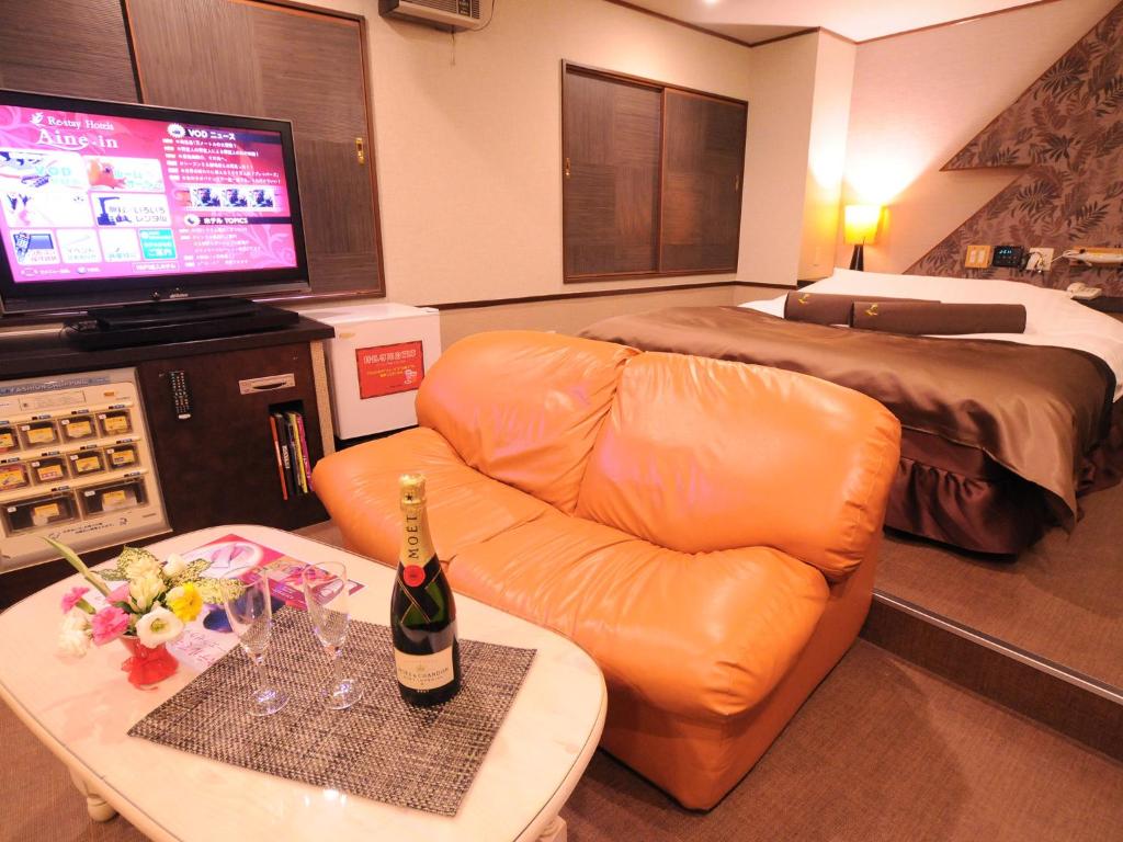 une chambre d'hôtel avec un canapé et un lit dans l'établissement Restay Morioka - Adult Only, à Morioka