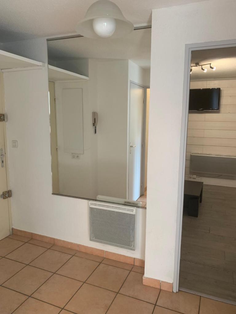 Cette chambre est dotée d'un mur blanc et d'un miroir. dans l'établissement SERRE CHEVALIER 1200, à Briançon