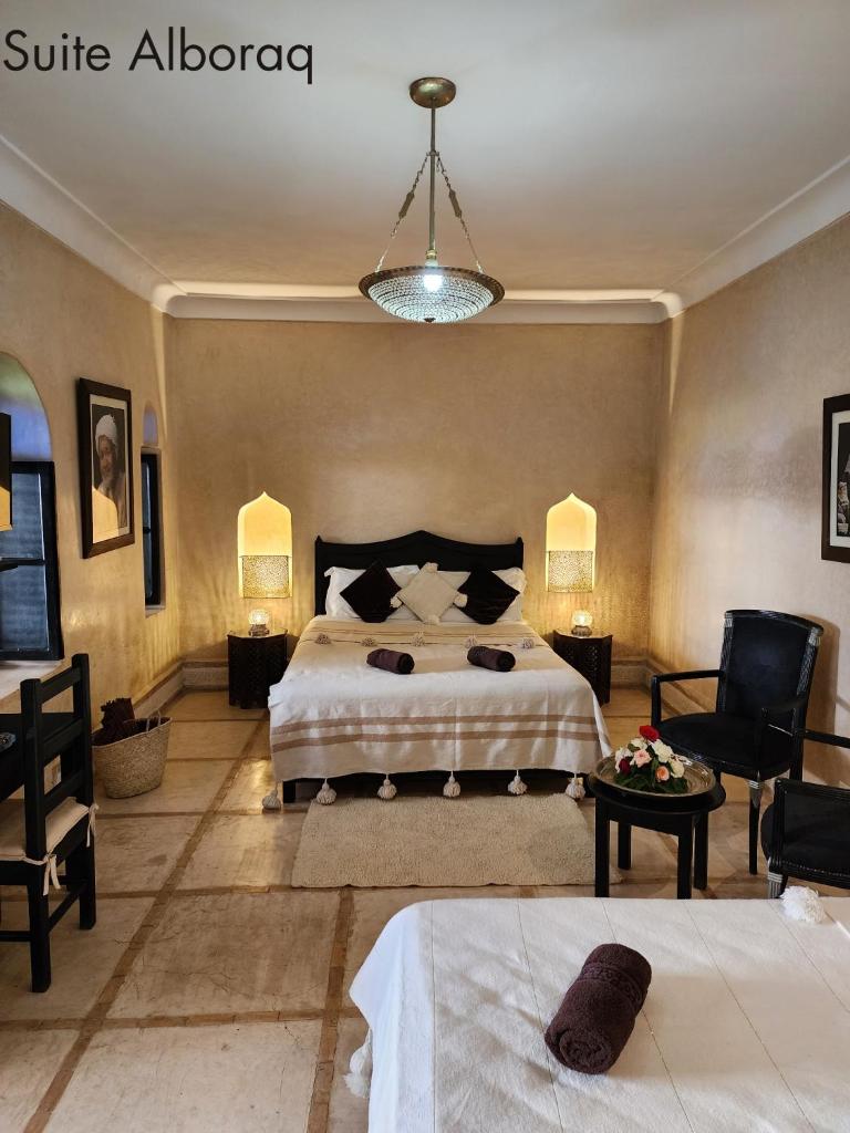 une chambre avec un lit, une chaise et une table dans l'établissement Riad Alboraq, à Marrakech