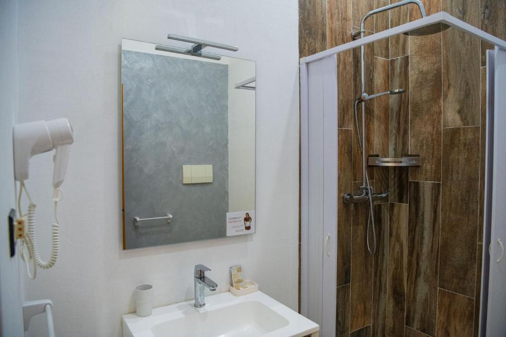 une salle de bain avec un lavabo et une douche dans l'établissement Hotel Parco Carabella, à Vieste