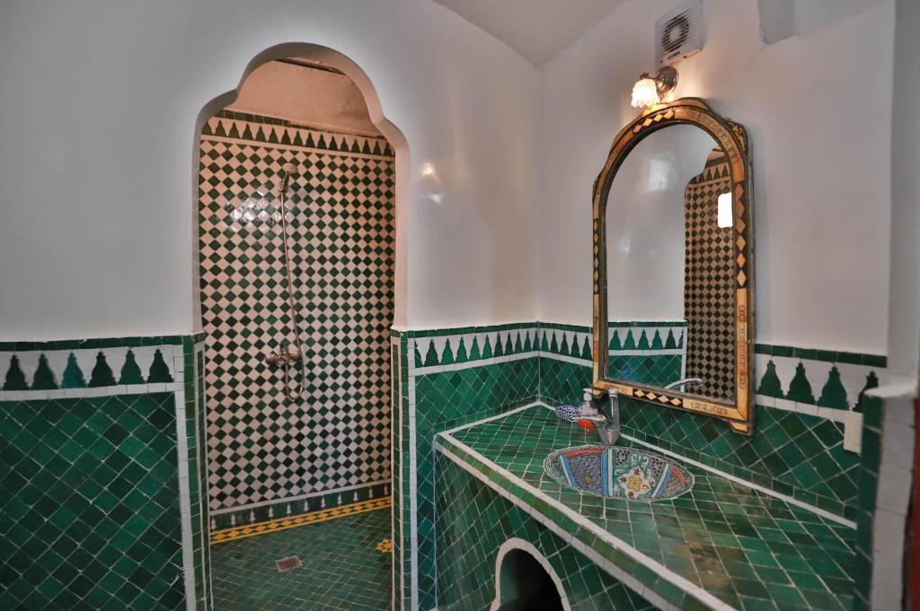 La salle de bains verte est pourvue d'un lavabo et d'un miroir. dans l'établissement Dar Elinor, à Fès 37 autres photos
