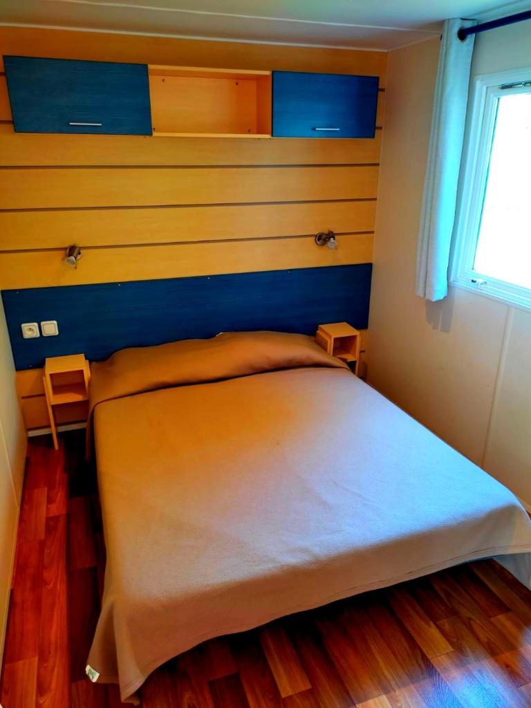 - une chambre avec un lit aux murs bleus et jaunes dans l'établissement Mobil Home près de l'entrée et de la piscine, à Saint-Chéron
