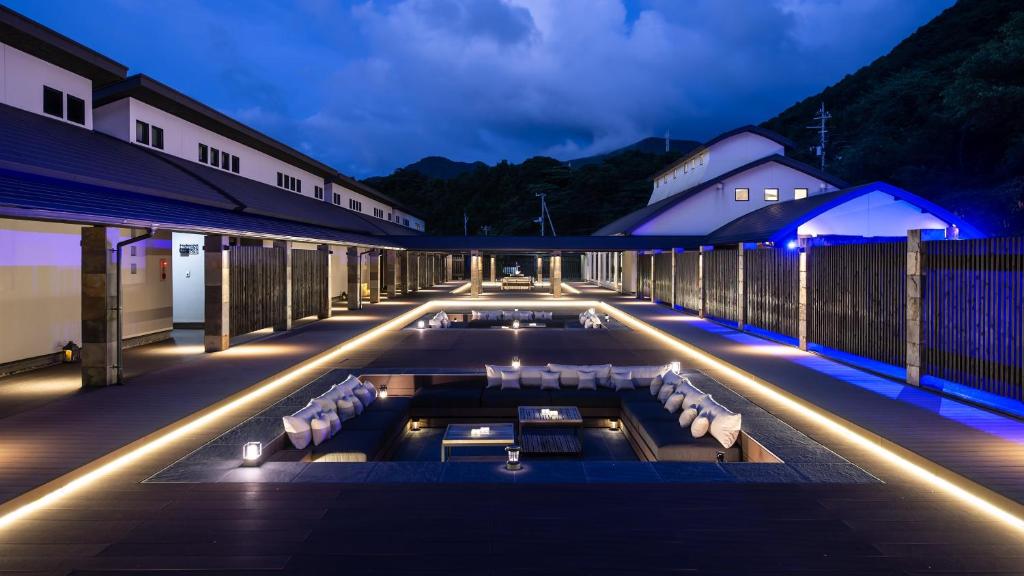 - une piscine avec des chaises et des lumières sur un bâtiment dans l'établissement Fugaku Gunjo, à Izu