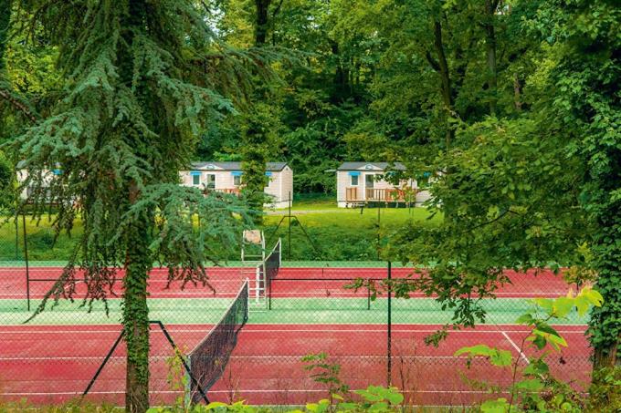 - un ensemble de courts de tennis avec des arbres et des maisons dans l'établissement location mobil-home le parc des roches, à Saint-Chéron