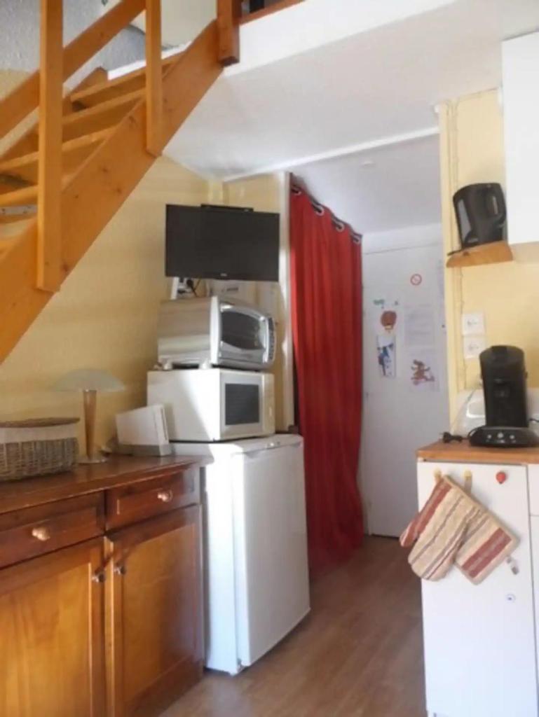 La cuisine est équipée d'un réfrigérateur blanc et d'un four micro-ondes. dans l'établissement Azur Sancy Skis aux pieds, à Le Mont-Dore