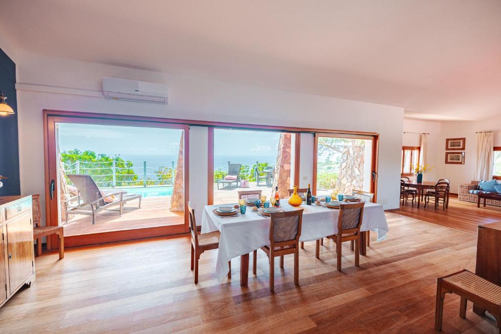 une salle à manger avec une table et une grande fenêtre dans l'établissement Tenuta Delle Ripalte, à Capoliveri