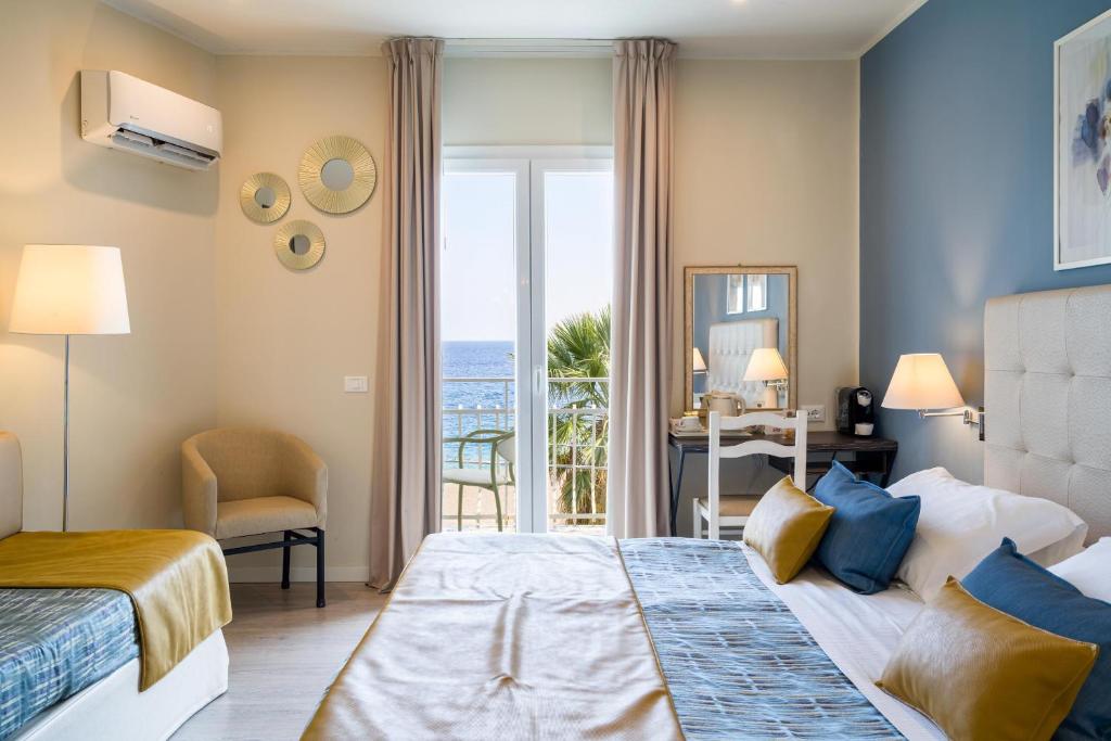 une chambre avec un lit et une vue sur l'océan dans l'établissement Hotel Rivage Taormina, à Taormine