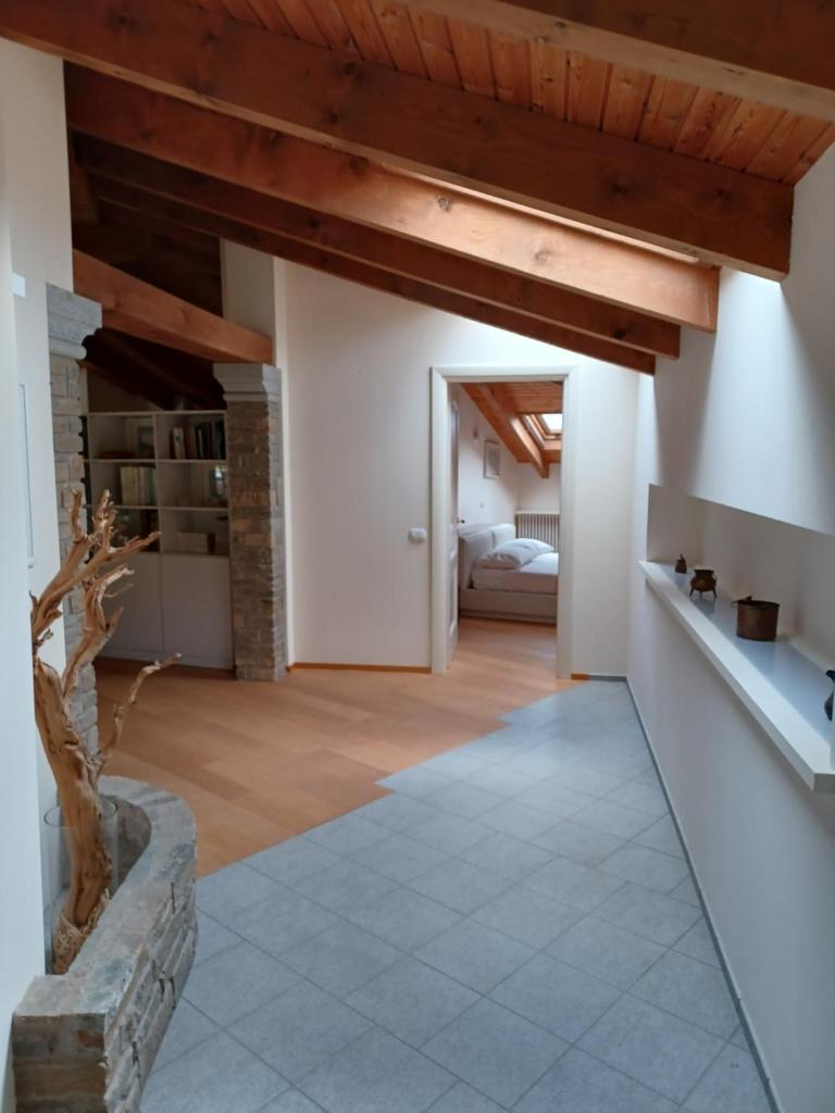 Elle comprend un grand salon avec des murs blancs et des plafonds en bois. dans l'établissement Penthouse in the green with private pool and garden, à Portula