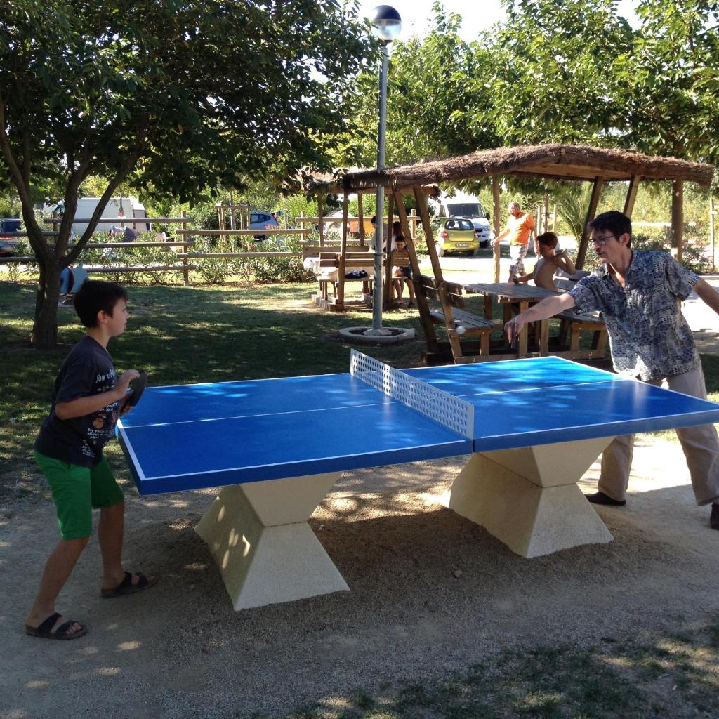 un homme et un garçon jouant au tennis de table dans l'établissement Camping L' Arlesienne, à Arles