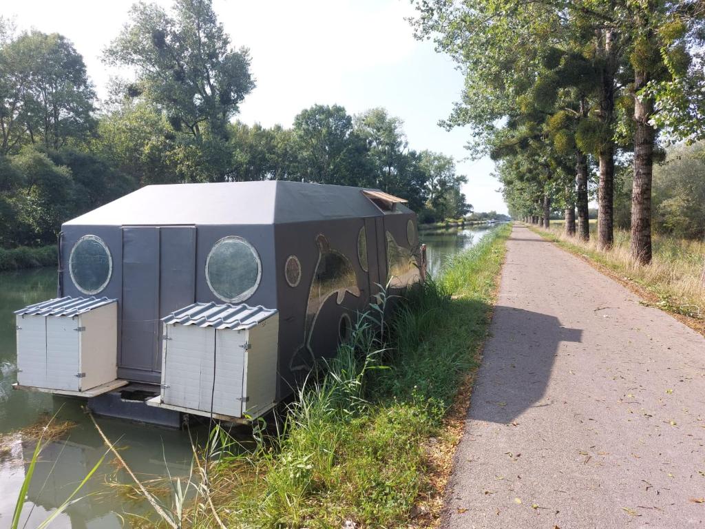 une petite maison assise au bord d'une rivière dans l'établissement Bateau studio terrasse vue sur l'eau et nature, à Saint-Usage