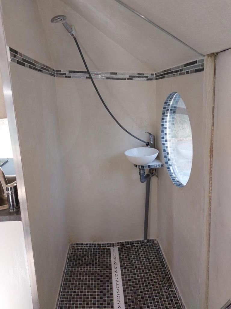 une petite salle de bain avec un lavabo et un miroir dans l'établissement Bateau studio terrasse vue sur l'eau et nature, à Saint-Usage