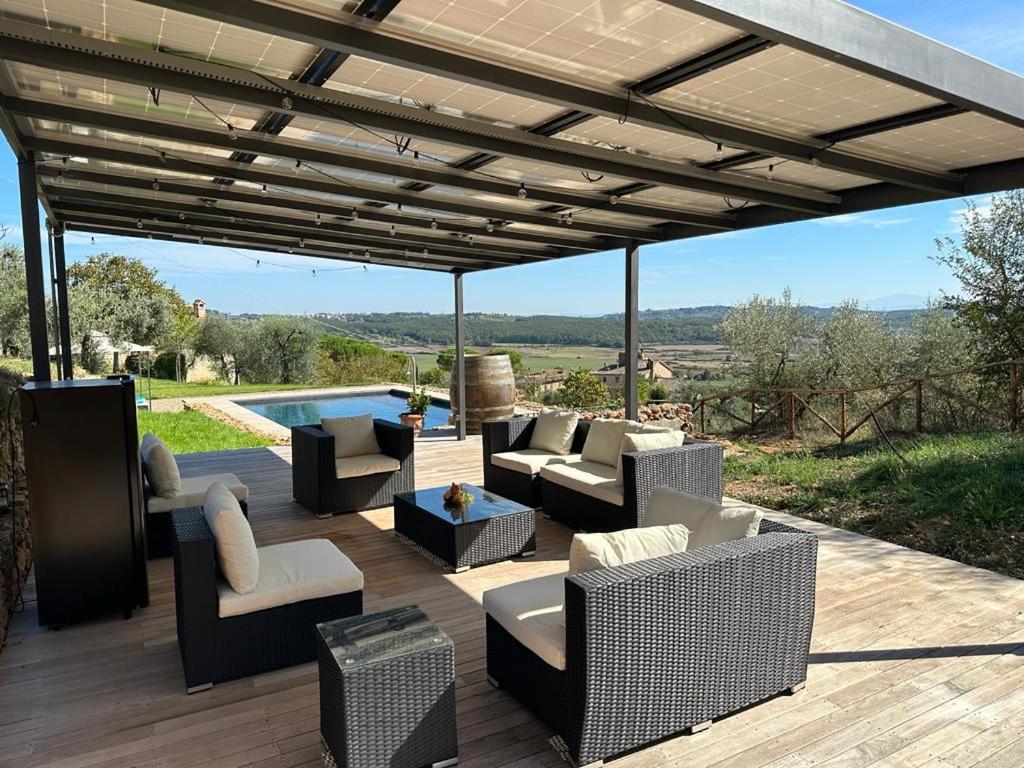une terrasse en bois avec des canapés et des chaises. dans l'établissement Il giardino sotto le stelle, à Fungaia