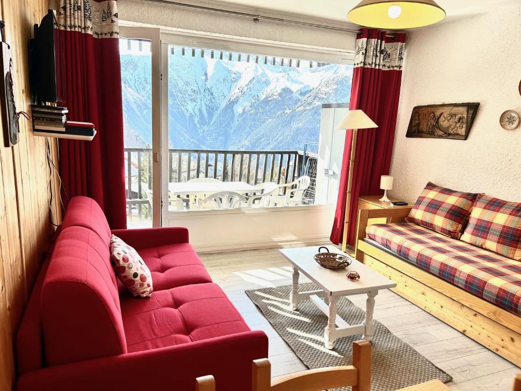 - un salon avec un canapé rouge et une grande fenêtre dans l'établissement Pied de Piste à 20 M du telesiege "Le Diable", Menage Inclus, Possible de louer 2 Apparts, Vue Panoramique, à Les Deux Alpes