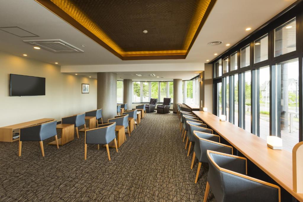 - une salle de conférence avec des chaises, des tables et une télévision dans l'établissement Niseko Hot Spring Ikoino Yuyado Iroha, à Niseko