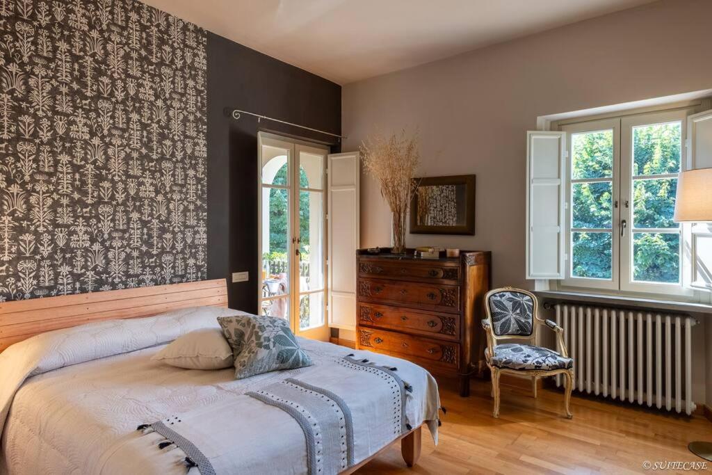 une chambre avec un lit, une chaise et des fenêtres dans l'établissement Atmosfera Japandi e Ricordi Lontani ,Luxury & Pool!, à Lucques
