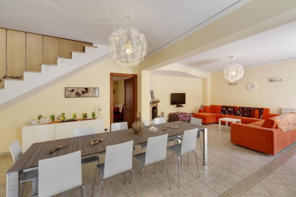 une salle à manger et un salon avec une table et des chaises dans l'établissement Villa Magda - private pool 20 pax, à Marina di Ragusa