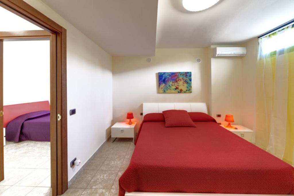 une chambre avec un lit rouge dans une pièce dans l'établissement Villa Magda - private pool 20 pax, à Marina di Ragusa