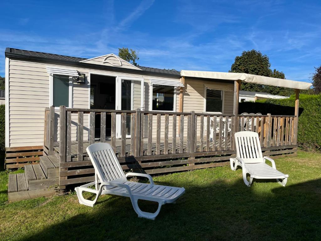 deux chaises longues assises dans l'herbe devant une maison dans l'établissement Mobil home 6 personnes dans camping 5*, à Houlgate