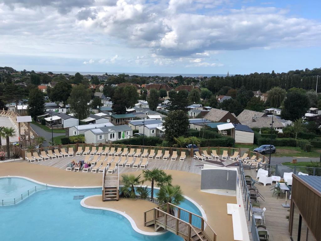 - une vue sur la piscine et la plage d'un complexe dans l'établissement Mobil home 6 personnes dans camping 5*, à Houlgate