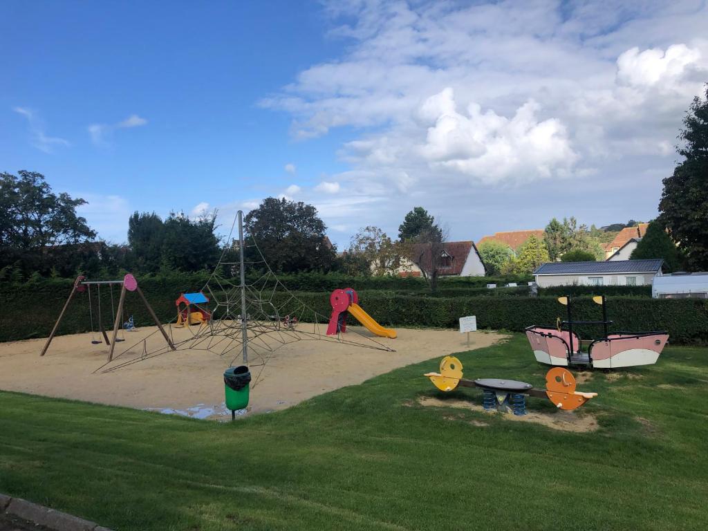 - un parc avec une aire de jeux dotée de toboggans et de balançoires dans l'établissement Mobil home 6 personnes dans camping 5*, à Houlgate