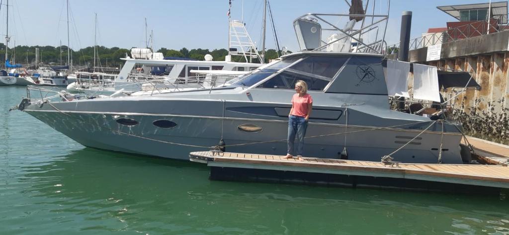 une femme debout sur un quai à côté d'un bateau dans l'établissement Bâteau cocoon en amoureux, à Bordeaux 7 autres photos