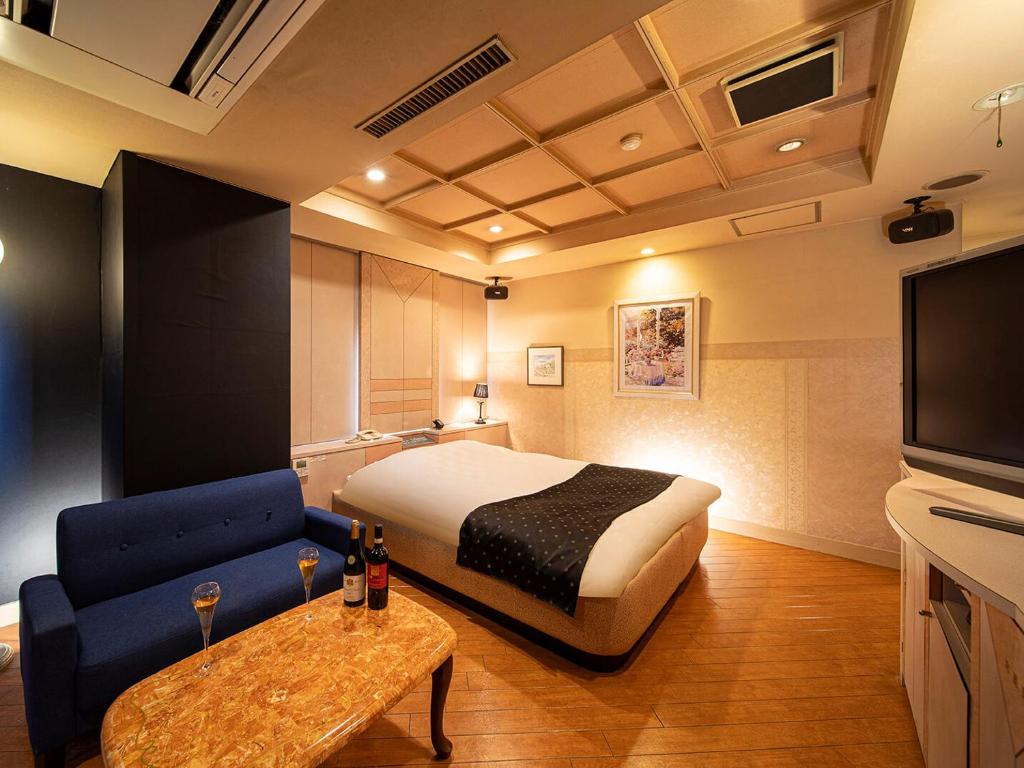 une chambre d'hôtel avec un lit, un canapé et une télévision dans l'établissement Saint martin (Adult Only), à Kyoto