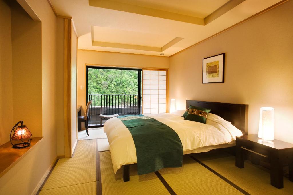 une chambre avec un lit et une fenêtre avec un balcon dans l'établissement Yukimurasaki, à Takayama