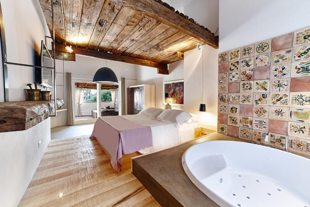 une chambre avec un lit et une baignoire dans l'établissement Praia Art Resort - Small Luxury Hotels of the world, à Le Castella