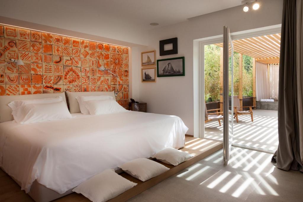 - une chambre avec un grand lit blanc et un mur orange dans l'établissement Praia Art Resort - Small Luxury Hotels of the world, à Le Castella 152 autres photos