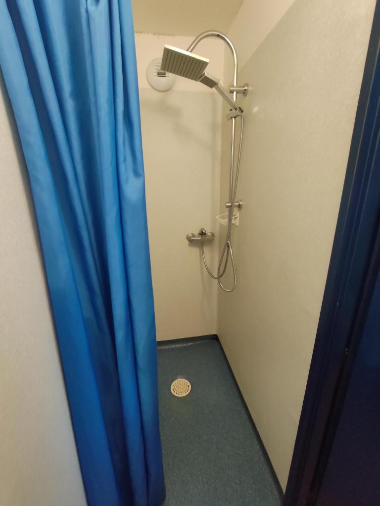 La salle de bains est pourvue d'une douche avec un rideau bleu. dans l'établissement Val Louron Pied des pistes apartment 34 m² 5 pers, à Génos 17 autres photos